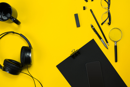 Black objects from the office on a yellow background. Work and creativity. Top view.の写真素材