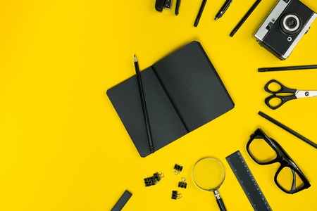 Black objects from the office on a yellow background. Work and creativity. Top view.の写真素材