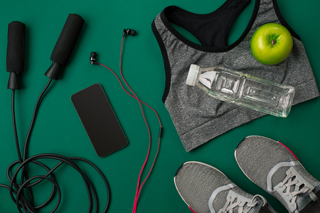 Athletes set with female clothing and bottle of water on green backgroundの写真素材