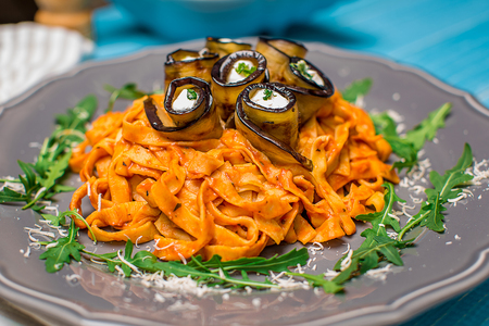 Pasta with eggplants, tomato, cheese and arugulaの写真素材