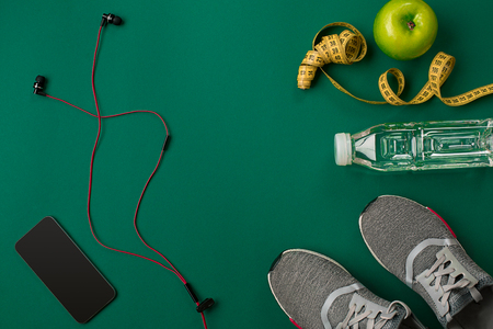 Athletes set with female clothing and bottle of water on green backgroundの写真素材