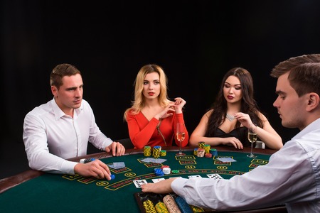 Friends enjoying a gambling night. The dealer deals the cardsの写真素材