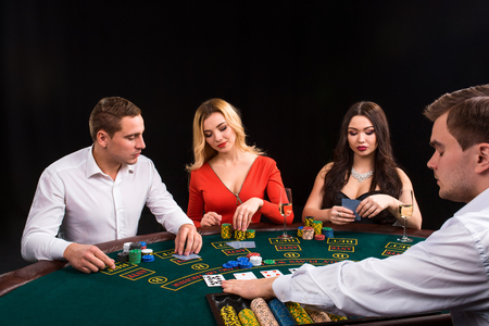Friends enjoying a gambling night. The dealer deals the cardsの写真素材