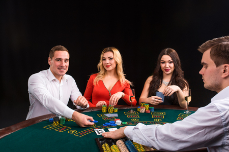 Friends enjoying a gambling night. The dealer deals the cardsの写真素材