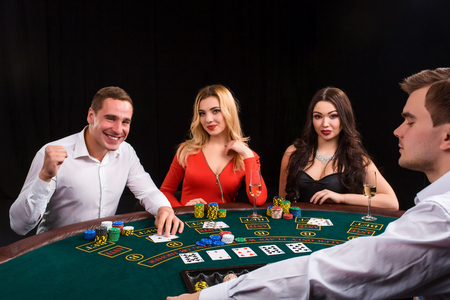 Friends enjoying a gambling night. The dealer deals the cardsの写真素材