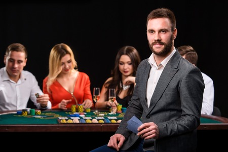 Poker players in casino with cards and chips on black backgroundの写真素材