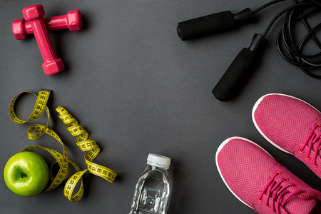 Athletes set with female clothing, sneakers and bottle of water on gray backgroundの写真素材