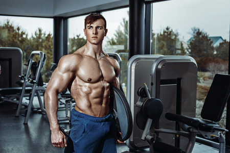 Male bodybuilder, fitness model trains in the gymの写真素材