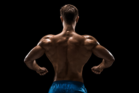 Strong Athletic Man Fitness Model posing back muscles, triceps over black backgroundの写真素材