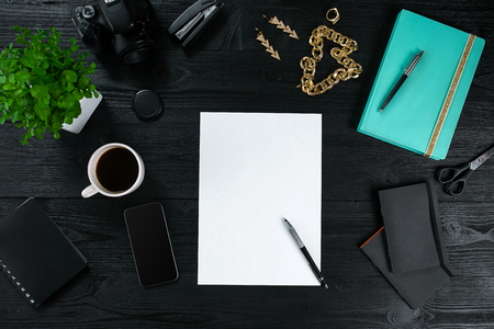 Flat lay, top view office table desk frame. Workspace with clean sheet of paper, mint diary and mobile device on dark background.の写真素材