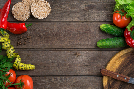 Sport and diet. Vegetables and centimeter. Peppers, tomatoes, salad on rustic backgroundの写真素材