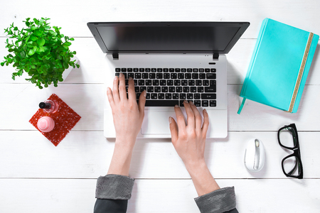 Laptop with blank screen and girls hands. Flat lay, top view workspaceの写真素材