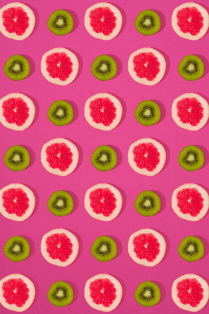 Grapefruit and kiwi pattern on pink background. Minimal flat lay concept.