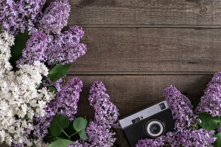 Lilac blossom on rustic wooden background with empty space for greeting message. Camera old. Top viewの写真素材