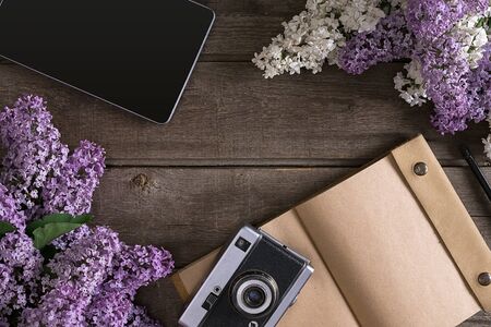 Lilac blossom on rustic wooden background with notebook for greeting message. Top viewの写真素材