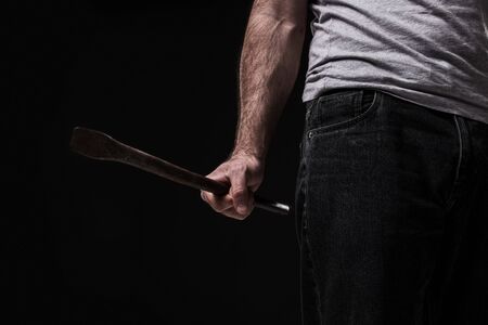 Male offender with a scrap. On black background at the studioの写真素材