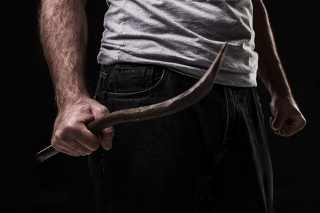 Male offender with a scrap. On black background at the studioの写真素材