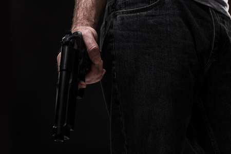 Killer with gun on black background at the studioの写真素材