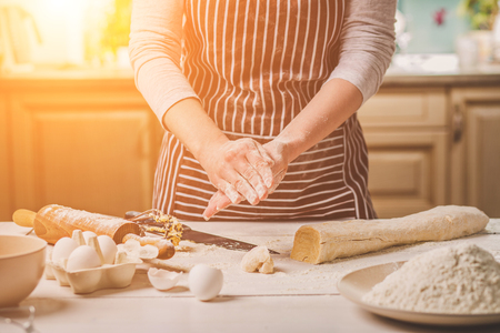 Woman bake pies. Confectioner makes desserts. Making buns. Dough on the table. Knead the dough.の写真素材
