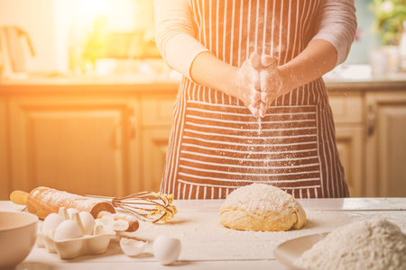 Woman slap his hands above dough closeup. Baker finishing his bakery, shake flour from his hands, free space for text.の写真素材