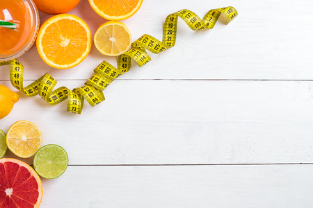 Fitness concept with fruit, a glass of juice and centimeter. Top view background concept.の写真素材