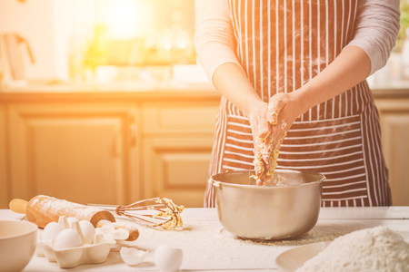 Woman hands kneading dough in iron bowlの写真素材
