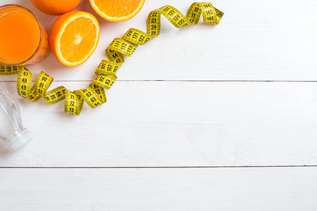 Fitness concept with fruit, a glass of juice and centimeter. Top view background concept.の写真素材