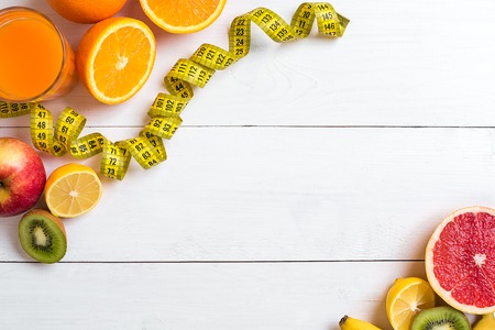 Fitness concept with fruit, a glass of juice and centimeter. Top view background concept.の写真素材