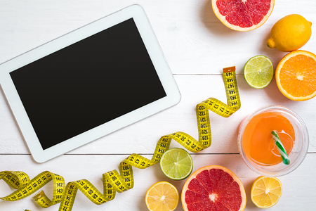 Fitness concept with fruit, a glass of juice and centimeter. Top view background concept.の写真素材