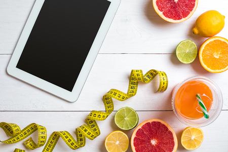 Fitness concept with fruit, a glass of juice and centimeter. Top view background concept.の写真素材