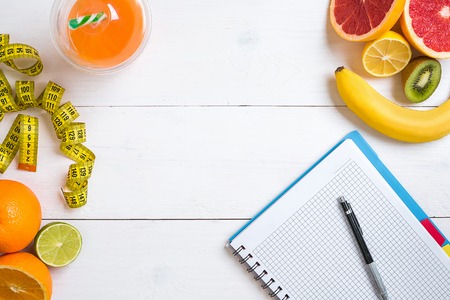 Fitness concept with fruit, a glass of juice and centimeter. Top view background concept.の写真素材