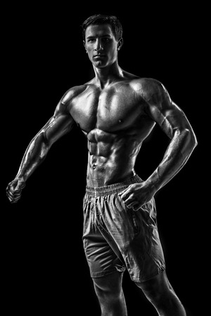 Muscular and fit young bodybuilder fitness male model posing oveの写真素材