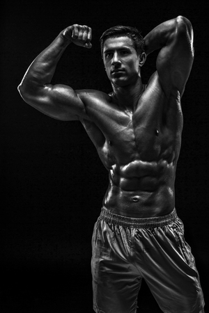 Muscular and fit young bodybuilder fitness male model posing oveの写真素材