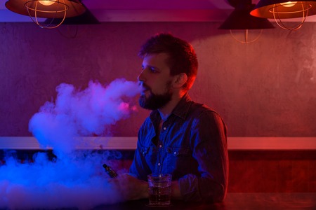 The man smoke an electronic cigarette at the vape shop.の写真素材