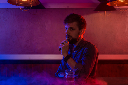 The man smoke an electronic cigarette at the vape shop.の写真素材