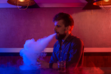 The man smoke an electronic cigarette at the vape shop.の写真素材
