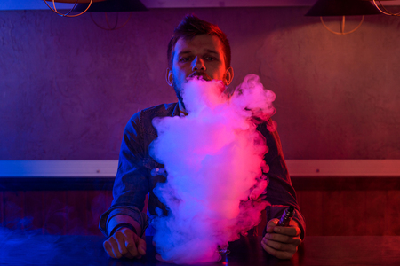 The man smoke an electronic cigarette at the vape shop.の写真素材