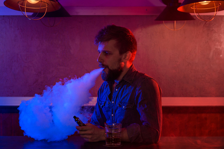 The man smoke an electronic cigarette at the vape shop.の写真素材
