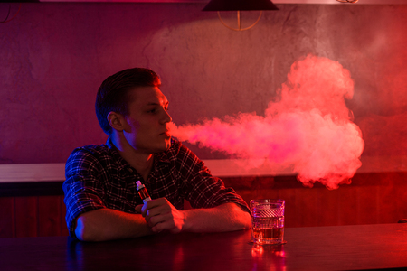 The man smoke an electronic cigarette at the vape shop.の写真素材