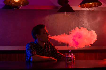 The man smoke an electronic cigarette at the vape shop.の写真素材