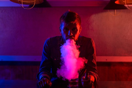 The man smoke an electronic cigarette at the vape shop.の写真素材