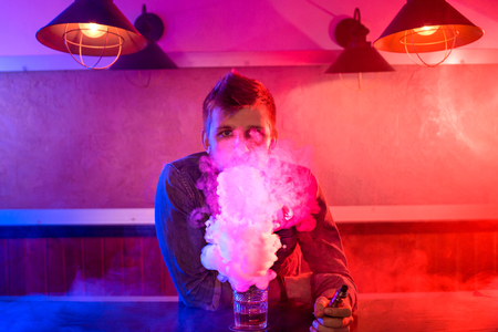 The man smoke an electronic cigarette at the vape shop.の写真素材