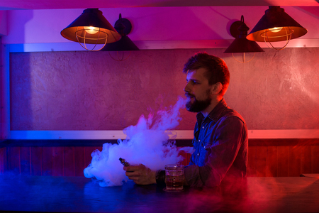 The man smoke an electronic cigarette at the vape shop.の写真素材