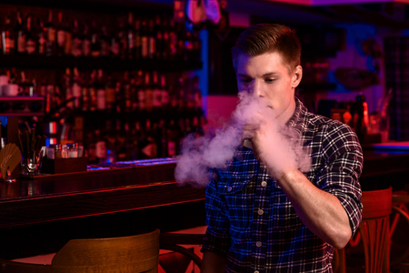 The man smoke an electronic cigarette at the vape shop.の写真素材