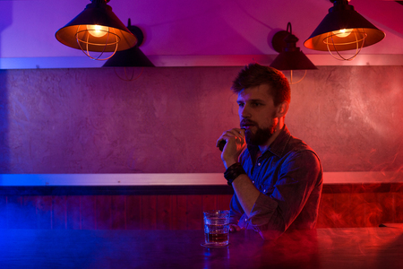 The man smoke an electronic cigarette at the vape shop.の写真素材