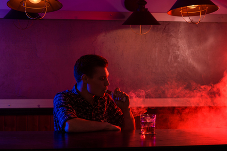 The man smoke an electronic cigarette at the vape shop.の写真素材