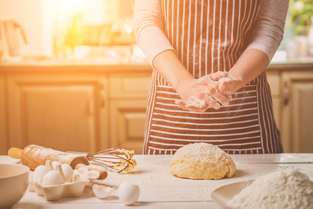 Woman slap his hands above dough closeup. Baker finishing his bakery, shake flour from his hands, free space for text.の写真素材