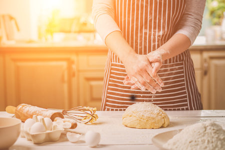 Woman slap his hands above dough closeup. Baker finishing his bakery, shake flour from his hands, free space for text.の写真素材