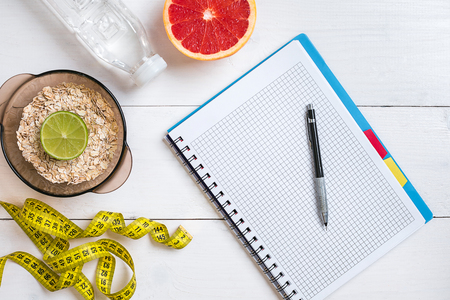 Fresh fruits with tape measure over white wooden background. Top viewの写真素材