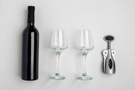 Red wine bottle, glasses and corkscrew over white background. Top view with copy spaceの写真素材